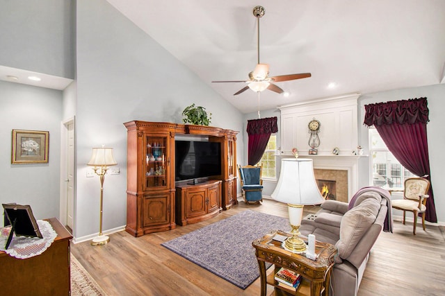 4261 Merriman Loop, Howell, MI 48843 - living area with ceiling fan, plenty of natural light, vaulted ceiling, light wood-style floors, and a tile fireplace