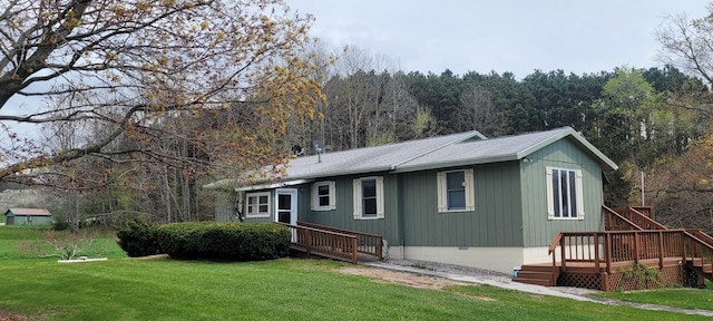 4131 W Meisenheimer Rd, Ludington, MI 49431 - back of property featuring a lawn, a wooden deck, a forest view, and crawl space