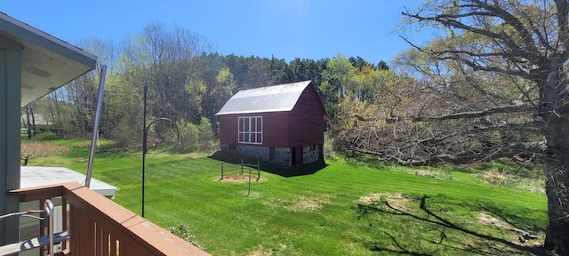 4131 W Meisenheimer Rd, Ludington, MI 49431 - view of green lawn featuring a wooded view, a barn, and an outdoor structure