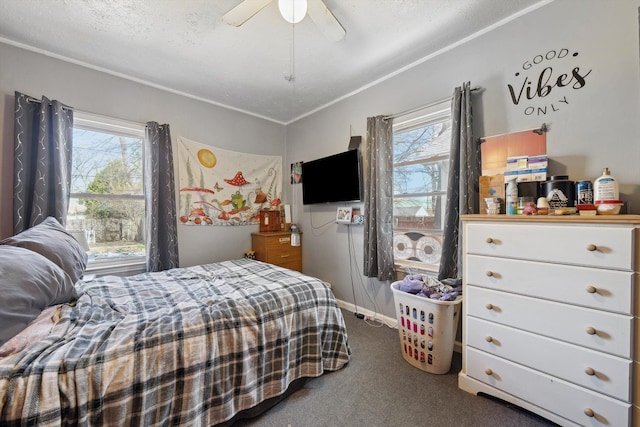 carpeted bedroom with ceiling fan, ornamental molding, baseboards, and a textured ceiling
