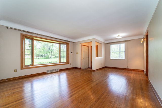 unfurnished living room featuring wood finished floors and baseboards