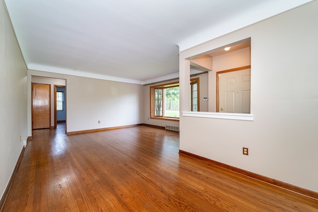 spare room featuring baseboards and wood finished floors