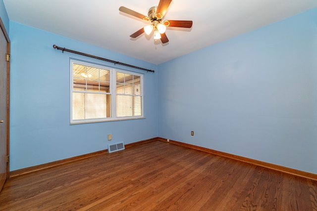 unfurnished room with wood finished floors, baseboards, and ceiling fan