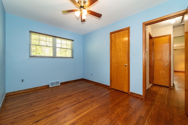 unfurnished bedroom with wood finished floors, baseboards, and ceiling fan