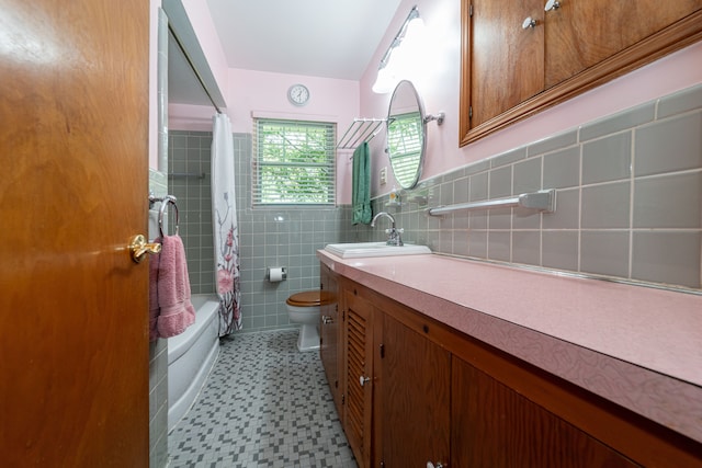 bathroom featuring tile patterned floors, tile walls, toilet, vanity, and shower / tub combo with curtain