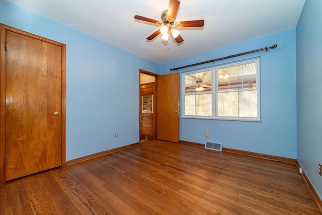 unfurnished bedroom with wood finished floors, baseboards, and a ceiling fan