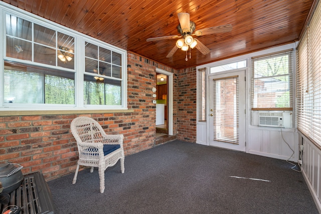 unfurnished sunroom with a ceiling fan, healthy amount of natural light, and cooling unit
