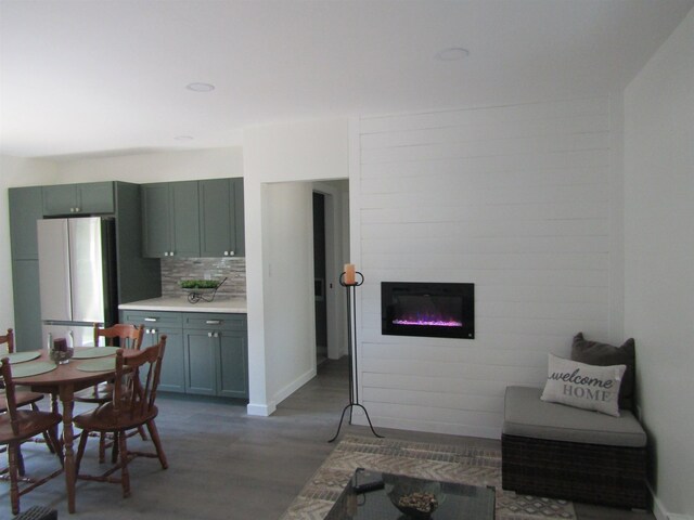 1192 Little Creek Rd SE, Alger, MI 48610 - kitchen with freestanding refrigerator, wood finished floors, a fireplace, light countertops, and backsplash