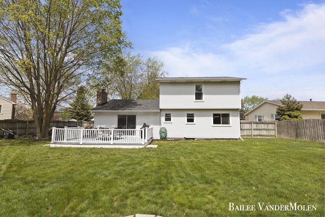 back of property with a chimney and a deck