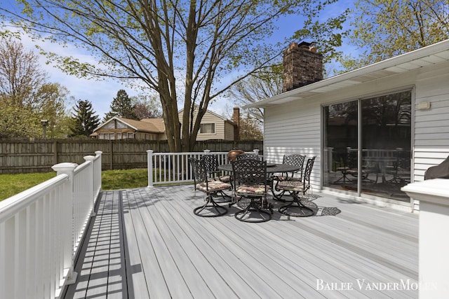 deck featuring outdoor dining area and a fenced backyard