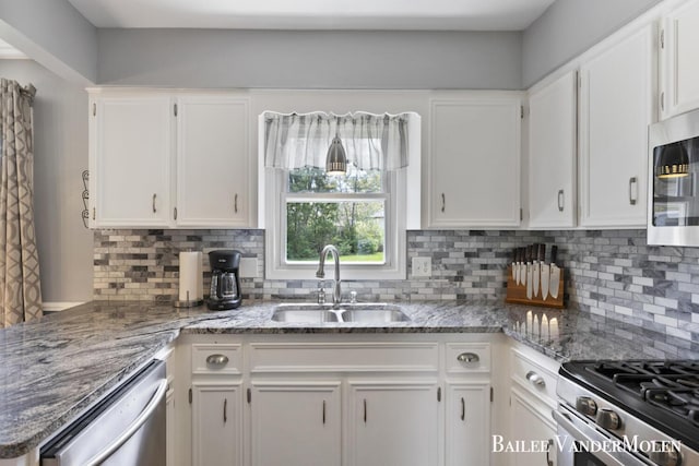 kitchen featuring a sink, stainless steel appliances, white cabinets, and decorative backsplash