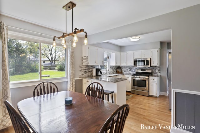 dining space with healthy amount of natural light and light wood-style flooring