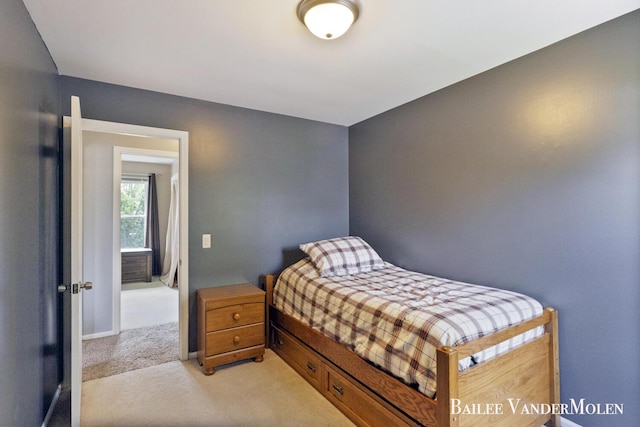 bedroom featuring light colored carpet and baseboards