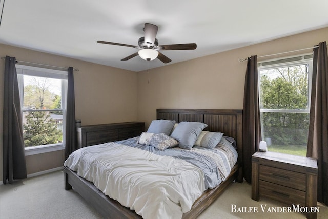 carpeted bedroom with multiple windows and a ceiling fan