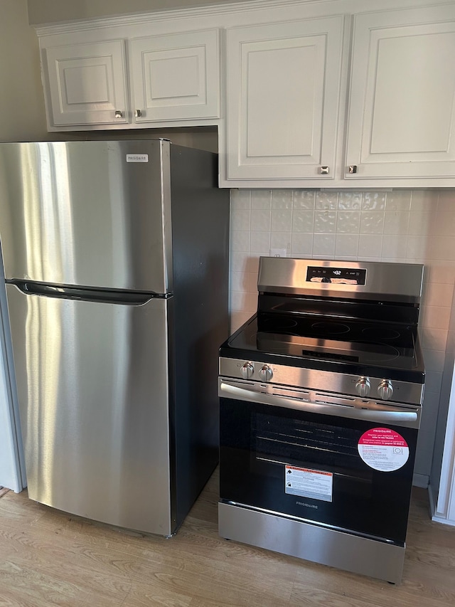 3608 W Webster Rd, Royal Oak, MI 48073 - kitchen featuring appliances with stainless steel finishes, white cabinets, backsplash, and light wood-type flooring