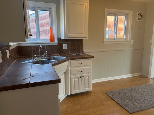 3608 W Webster Rd, Royal Oak, MI 48073 - kitchen with a sink, light wood-style flooring, dark countertops, and white cabinets
