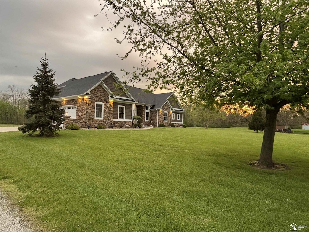 craftsman house featuring stone siding and a front yard