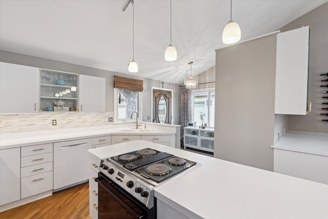 9669 Norman Rd, Clarkston, MI 48348 - kitchen with stove, a sink, light countertops, white cabinetry, and lofted ceiling