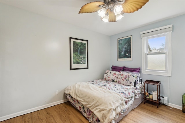9669 Norman Rd, Clarkston, MI 48348 - bedroom with baseboards, light wood-type flooring, a baseboard radiator, and a ceiling fan