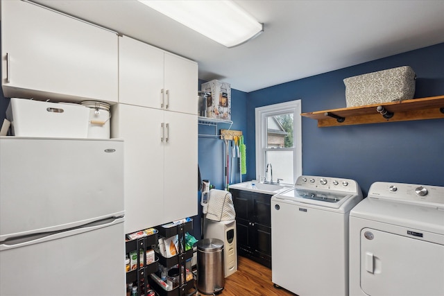9669 Norman Rd, Clarkston, MI 48348 - washroom with cabinet space, washing machine and clothes dryer, and light wood-style flooring
