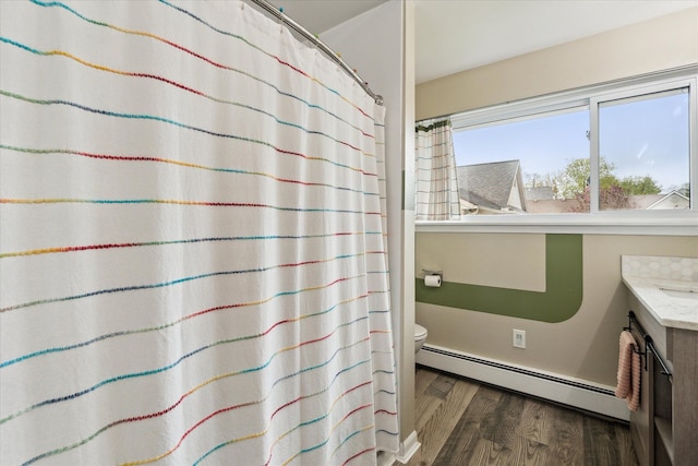 9669 Norman Rd, Clarkston, MI 48348 - full bathroom with a baseboard heating unit, wood finished floors, toilet, vanity, and a shower with curtain