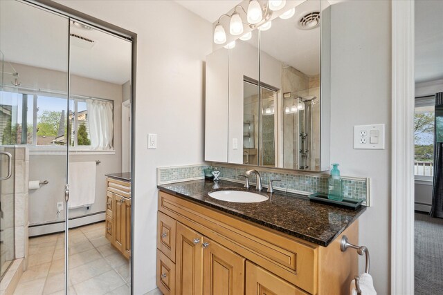 9669 Norman Rd, Clarkston, MI 48348 - full bathroom featuring a baseboard heating unit, a stall shower, healthy amount of natural light, and tasteful backsplash