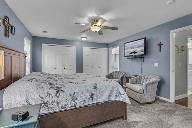739 W Barrington Cir, Jackson, MI 49203 - bedroom featuring multiple closets, baseboards, ensuite bath, carpet, and a ceiling fan