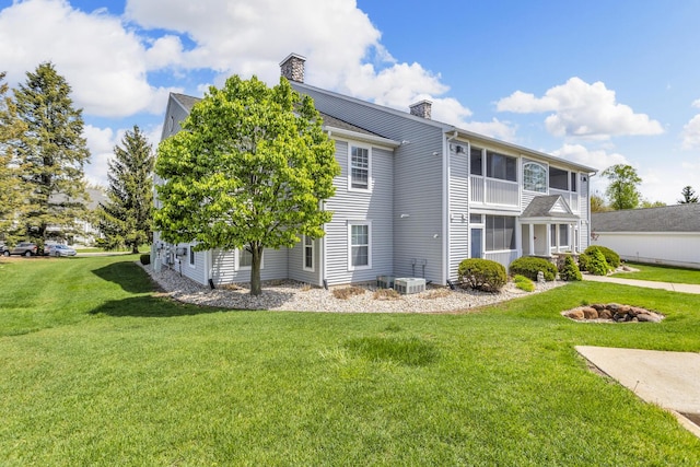 739 W Barrington Cir, Jackson, MI 49203 - rear view of house with a chimney and a lawn