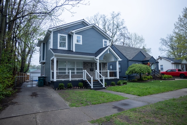 view of front of home featuring a porch, an outdoor structure, stone siding, and a gate