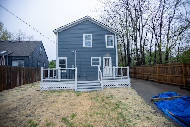 back of property with a deck and a fenced backyard