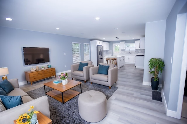 living room featuring recessed lighting, light wood-style flooring, and baseboards
