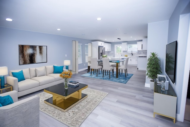 living room with recessed lighting, light wood-style floors, and baseboards
