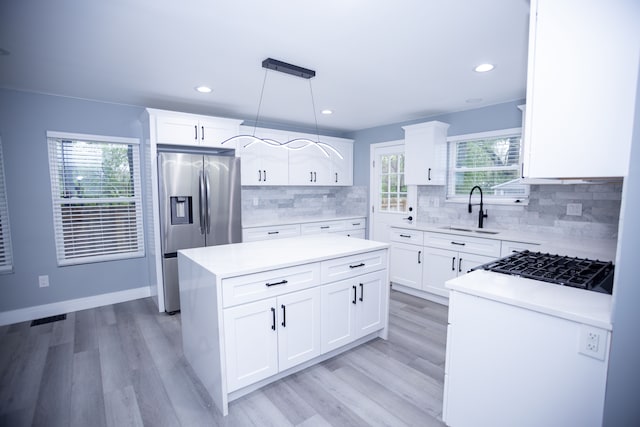 kitchen with stainless steel fridge with ice dispenser, a sink, light wood-type flooring, a kitchen island, and recessed lighting