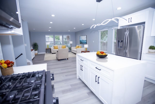 kitchen featuring stainless steel refrigerator with ice dispenser, recessed lighting, light wood-type flooring, white cabinetry, and a kitchen island