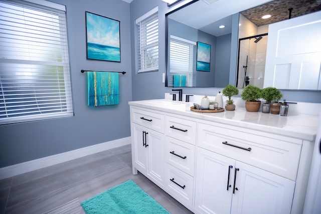 full bath featuring a shower stall, vanity, and baseboards