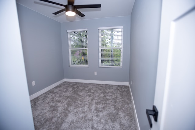 carpeted empty room featuring ceiling fan and baseboards