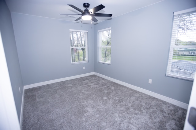 spare room with a ceiling fan, carpet floors, and baseboards