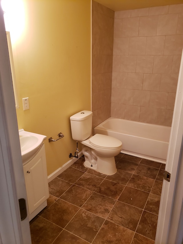 bathroom with toilet, vanity, tile patterned flooring, baseboards, and shower / washtub combination