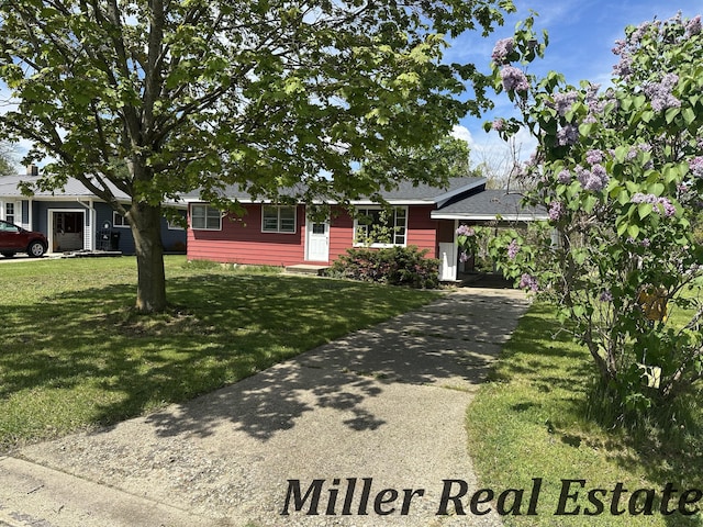 ranch-style house featuring a front yard, driveway, and an attached carport