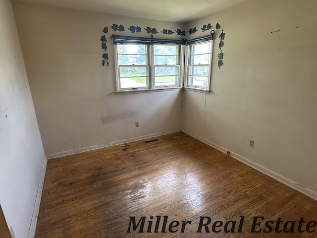 empty room with wood finished floors and baseboards