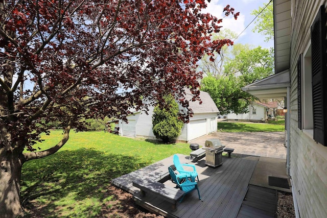 view of green lawn featuring an outbuilding, a deck, and a detached garage