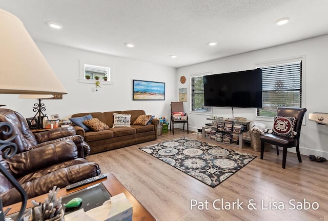 living room featuring wood finished floors, recessed lighting, and baseboards