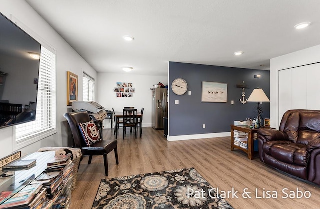 living area featuring wood finished floors, recessed lighting, and baseboards