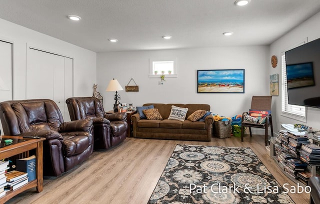 living area featuring light wood-style flooring and recessed lighting