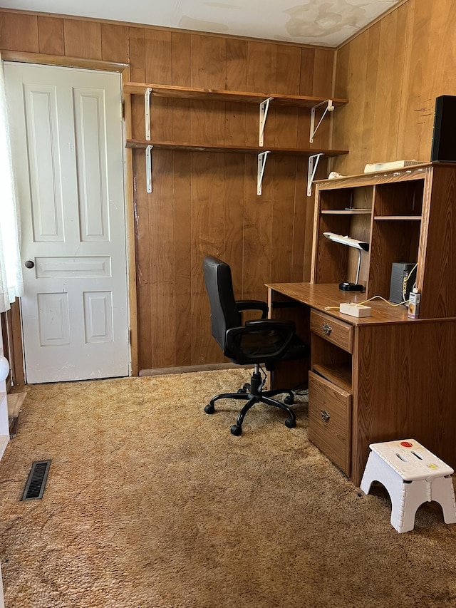 carpeted office featuring wood walls