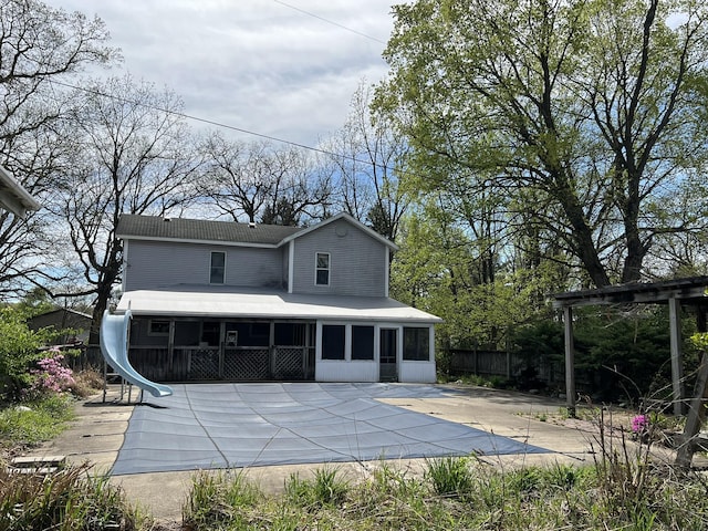 back of property featuring a sunroom, a patio, and fence