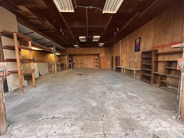 miscellaneous room featuring a garage, concrete floors, and wood walls