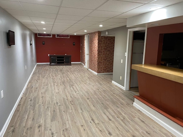 25432 Wexford Ave, Warren, MI 48091 - unfurnished living room featuring baseboards, wood finished floors, a drop ceiling, recessed lighting, and brick wall
