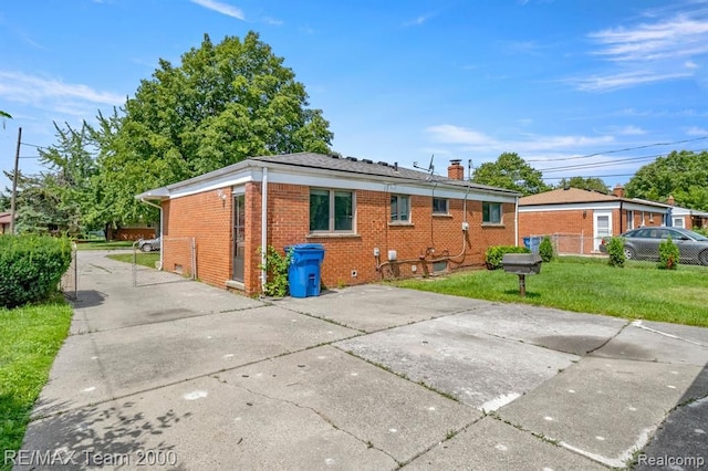25432 Wexford Ave, Warren, MI 48091 - rear view of house featuring brick siding, a chimney, and concrete driveway