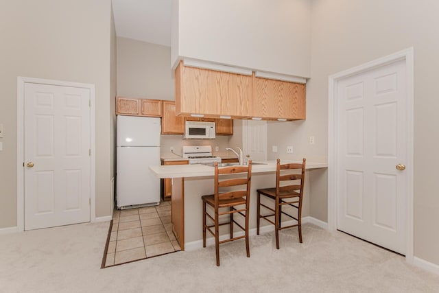 kitchen with white appliances, a towering ceiling, a peninsula, light countertops, and light colored carpet